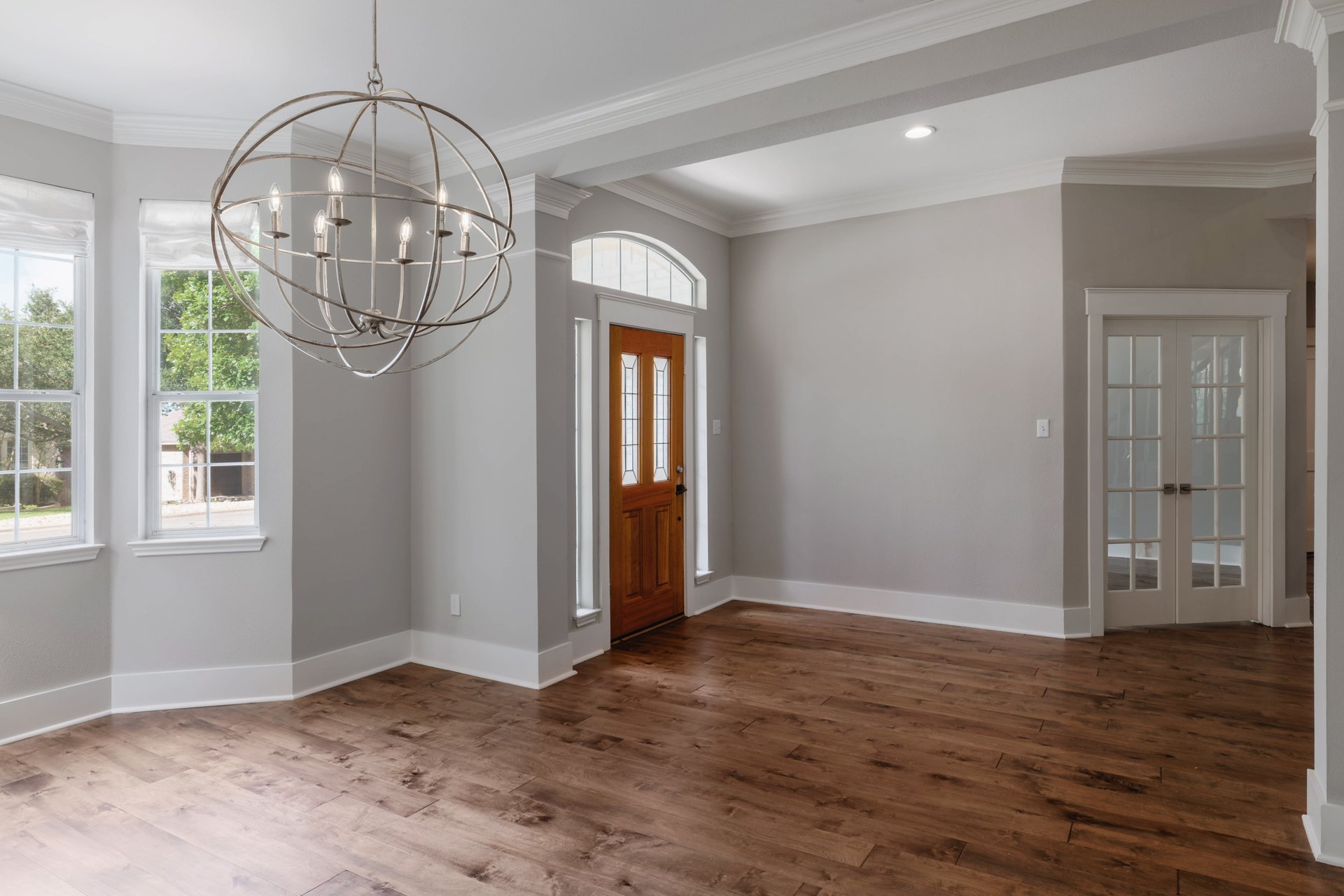 5512 Ballenton Lane Austin, TX 78739 - Photo 6 of 40 Rich hardwood floors welcome you into this elegant foyer, featuring an eye-catching chandelier and bay window.