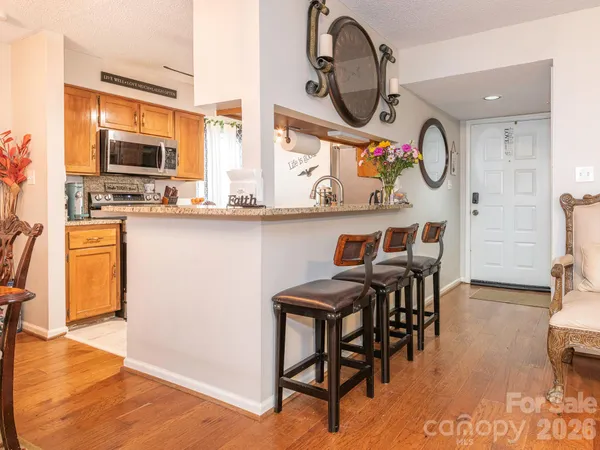 a group of chairs sitting in a kitchen and a dining table with wooden floor
