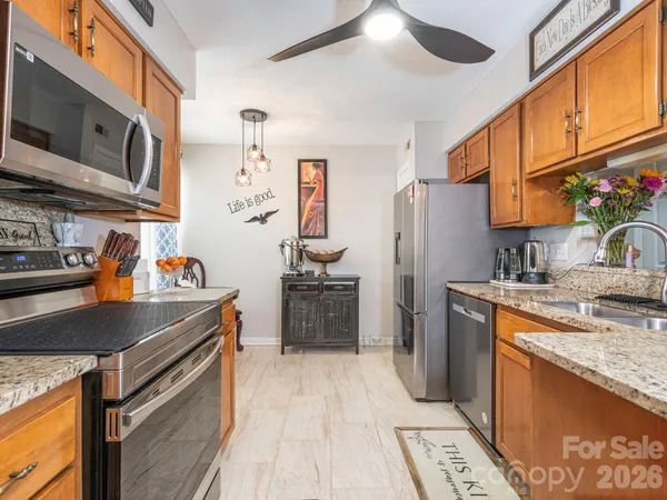 a kitchen with stainless steel appliances granite countertop a sink refrigerator and cabinets