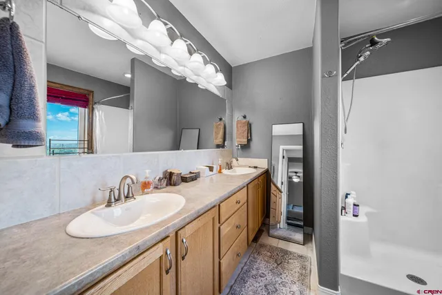 a bathroom with a double vanity sink mirror and bathtub