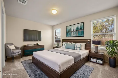 a bedroom with a large bed and a flat screen tv