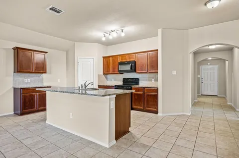 a kitchen with stainless steel appliances granite countertop a stove top oven a sink a counter top space and cabinets