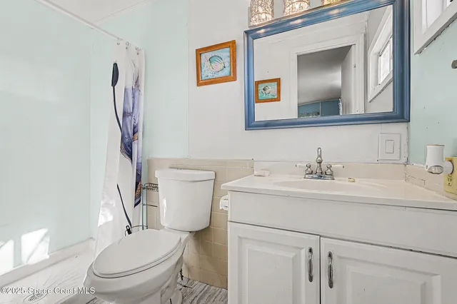 a bathroom with a granite countertop toilet sink and mirror