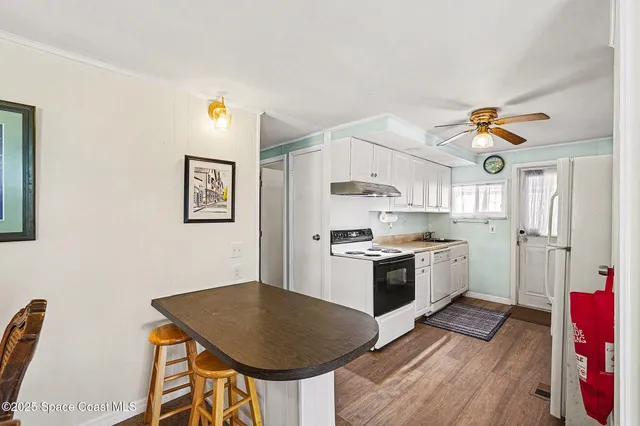 a kitchen with stainless steel appliances granite countertop a stove a sink dishwasher and a refrigerator with wooden floor