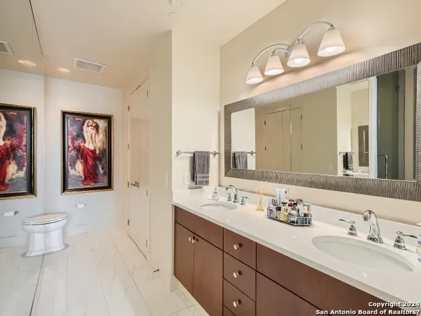 a bathroom with double vanity sinks and a mirror