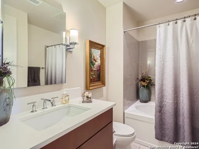 a bathroom with a sink a toilet a mirror and shower