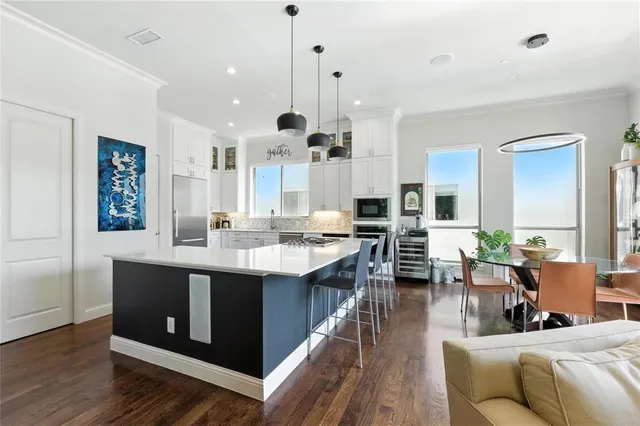 a large kitchen with lots of counter space a sink and living room view