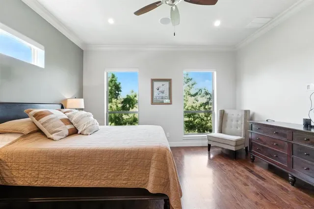 a bedroom with a large bed and wooden floor