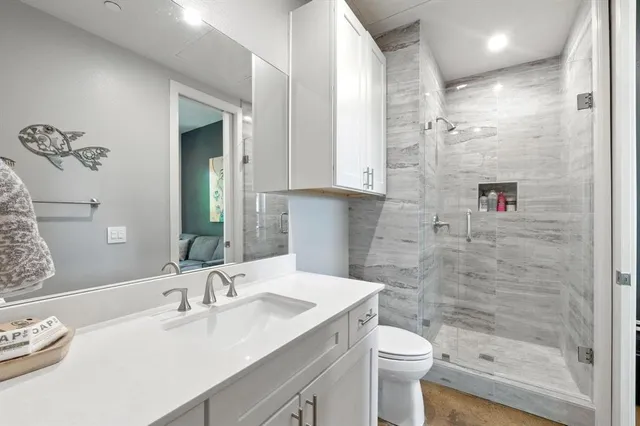 a bathroom with a sink a toilet and shower