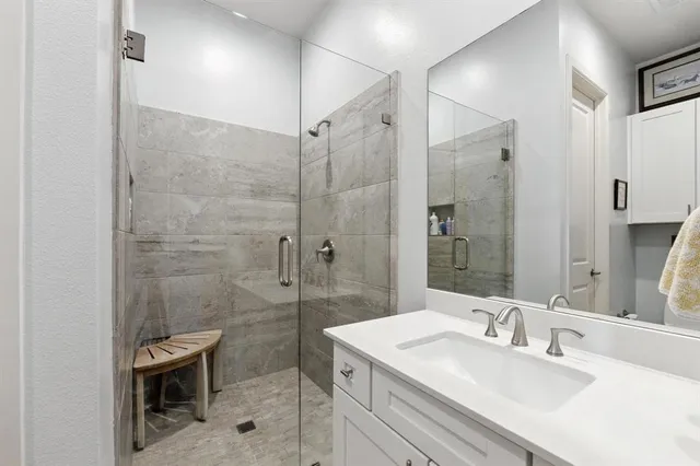 a bathroom with a sink shower and a mirror