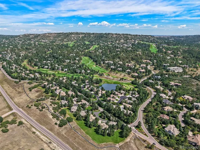 an aerial view of residential houses with outdoor space and trees