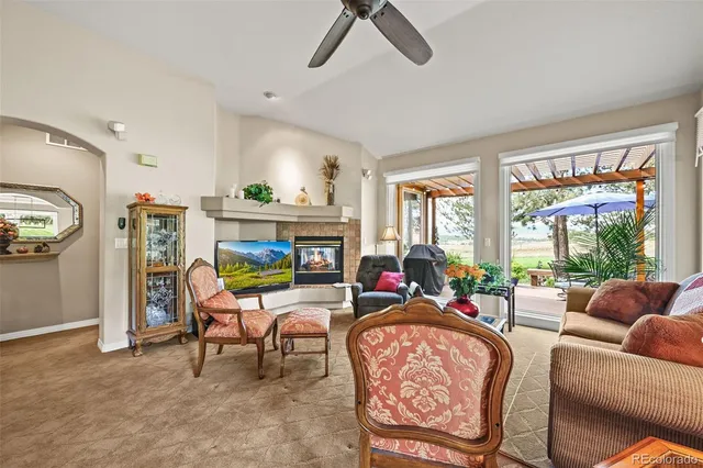 a living room with furniture a flat screen tv and a large window