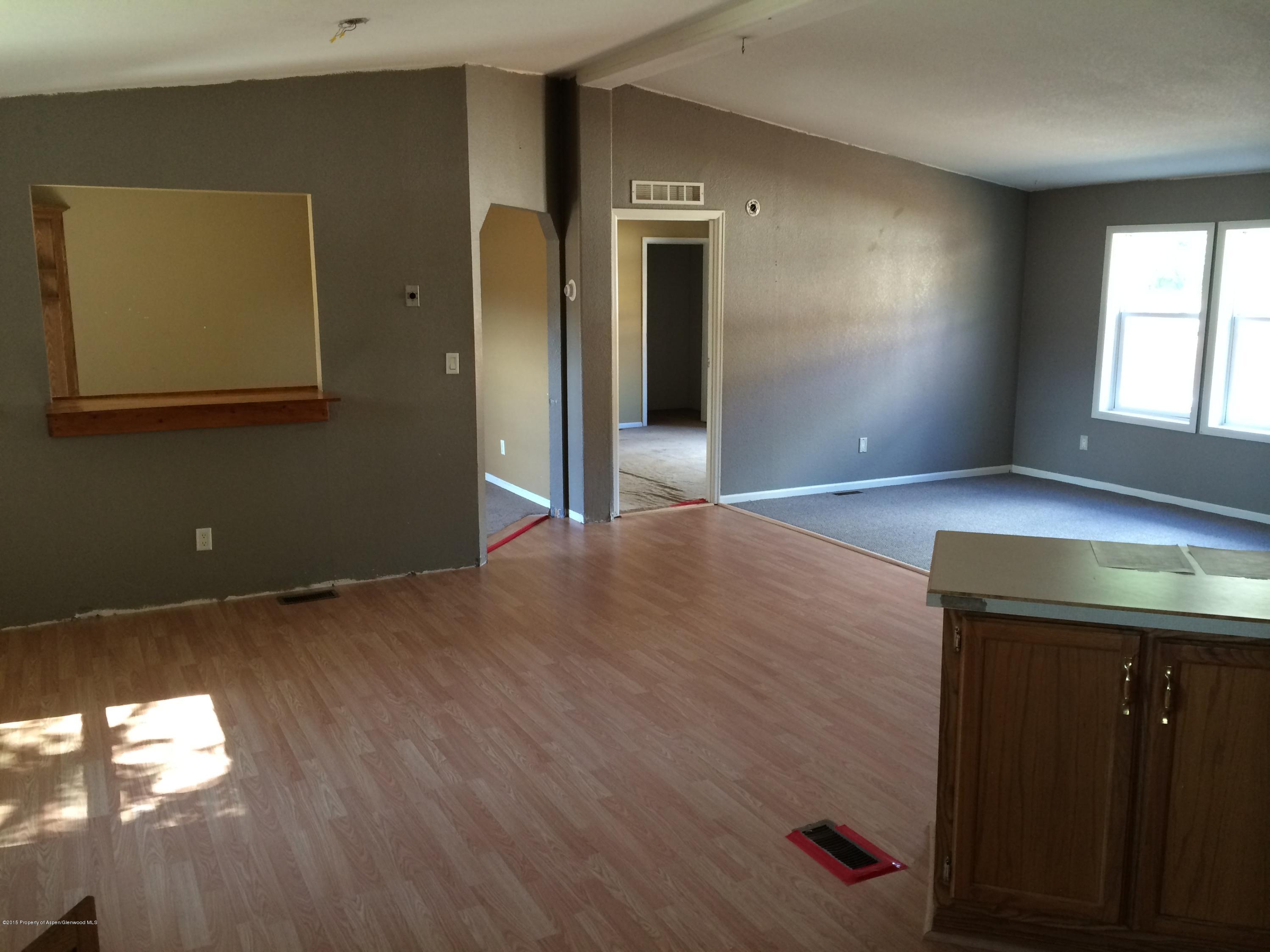 140 Ray Street Rifle, CO 81650 - Photo 4 of 11 wooden floor in an empty room with a window