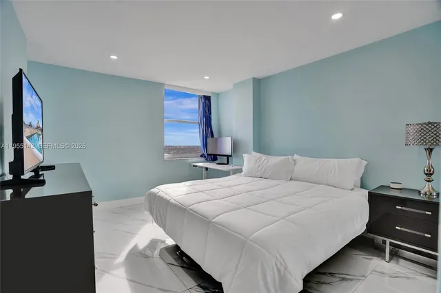 a bedroom with bed and a flat screen tv