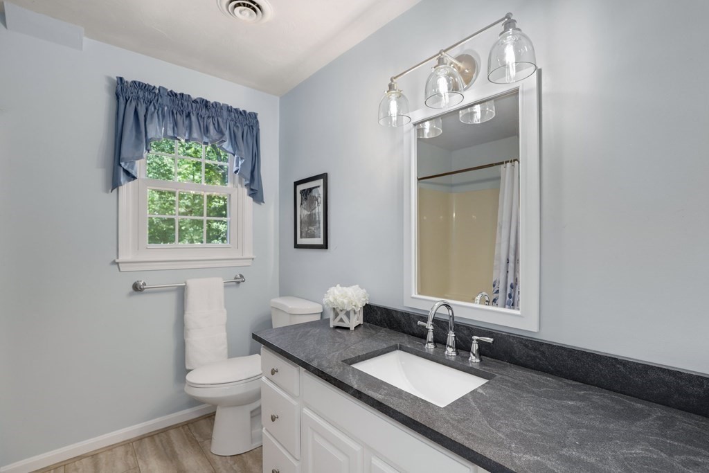 72 Nixon Road Framingham, MA 01701 - Photo 31 of 42 a bathroom with a granite countertop toilet a sink and mirror