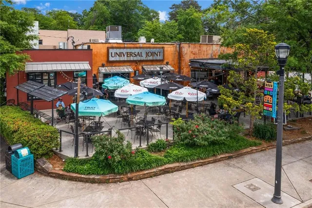 an aerial view of residential houses with outdoor space and trees