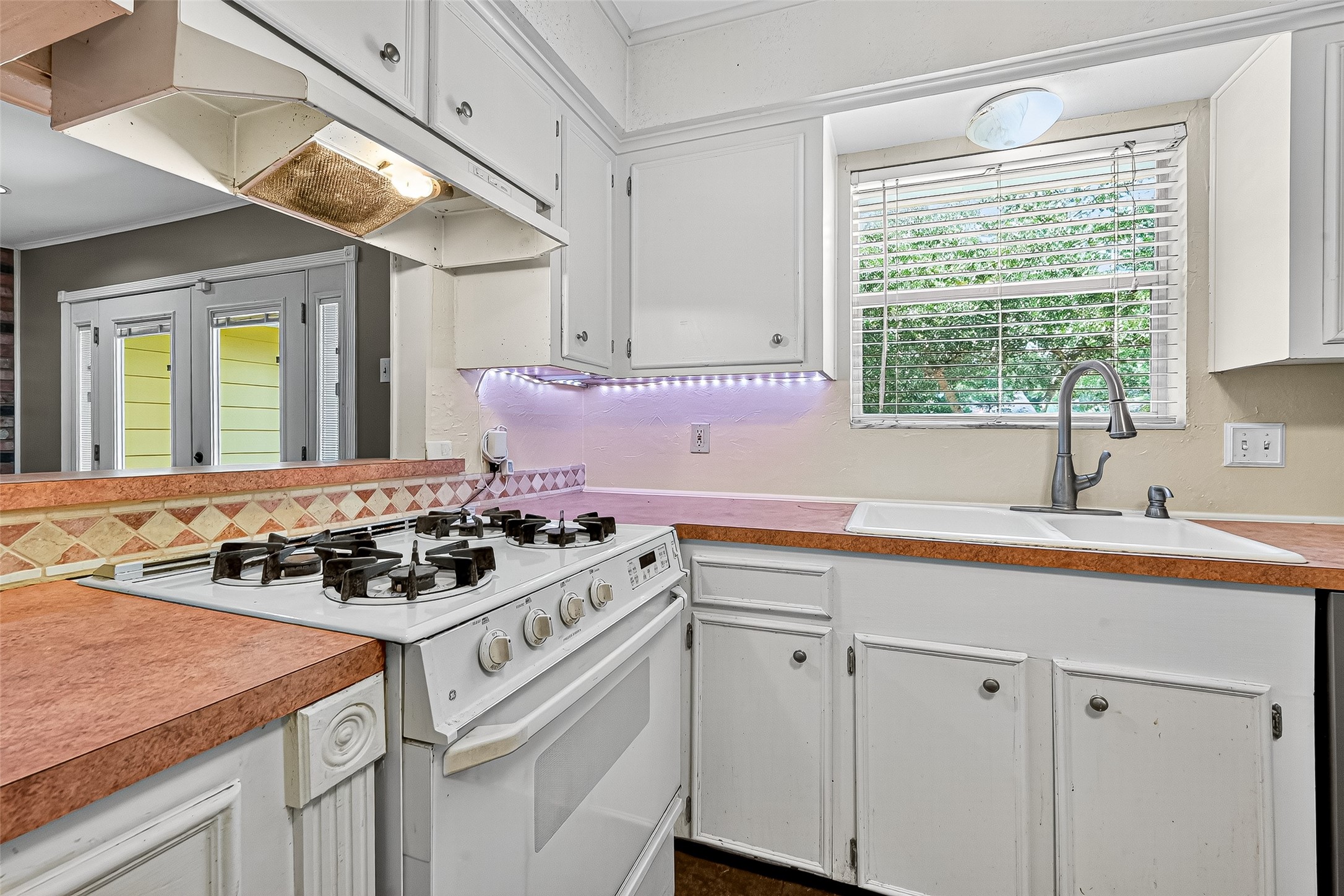 10302 Ivyridge Road Houston, TX 77043 - Photo 22 of 47 a kitchen with a stove a sink a refrigerator and window