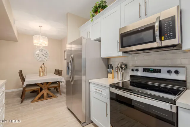 a kitchen with stainless steel appliances a stove a microwave and white cabinets
