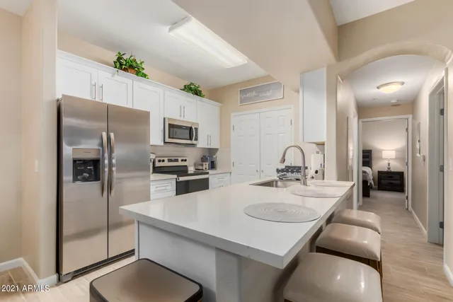 a kitchen with stainless steel appliances granite countertop a sink a stove and refrigerator