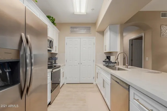 a kitchen with stainless steel appliances granite countertop a refrigerator and a sink