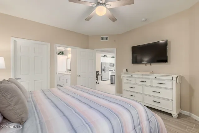 a bedroom with a bed a flat screen tv and a chandelier
