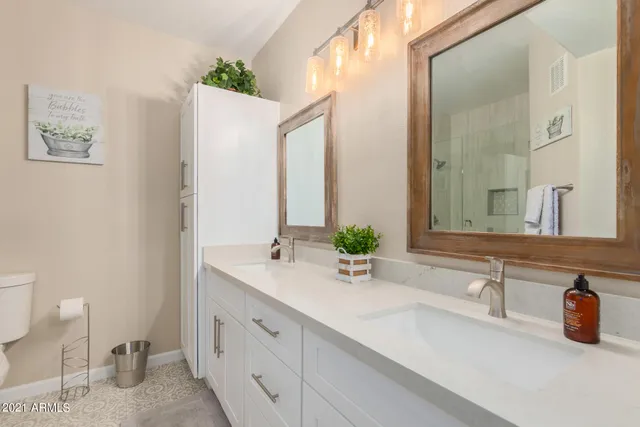 a bathroom with a double vanity sink and a mirror