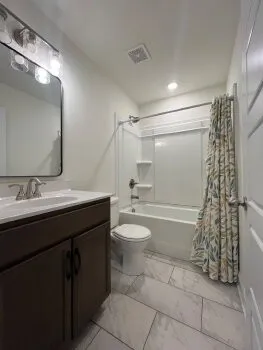 a bathroom with a granite countertop sink toilet and shower