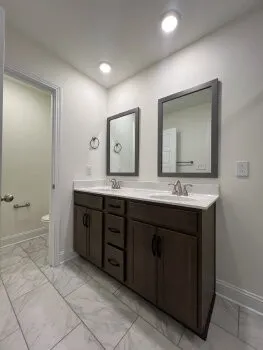a bathroom with a double vanity sink mirror and bathtub