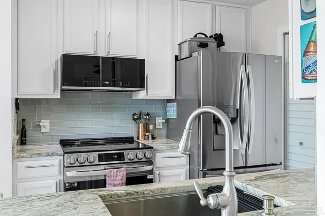 a kitchen with stainless steel appliances granite countertop a refrigerator and a stove top oven