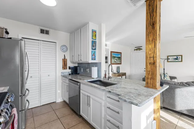 a kitchen with granite countertop a sink stove and refrigerator