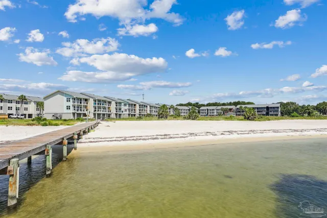 an aerial view of a city with lots of residential buildings ocean and mountain view in back