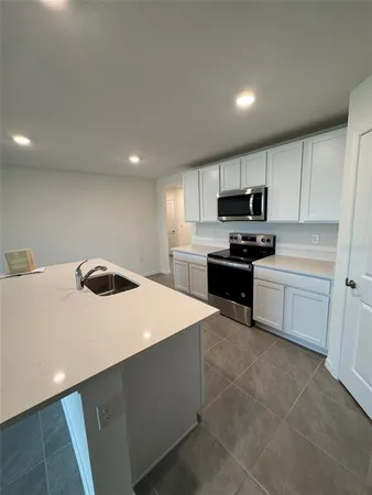 a kitchen with a sink a stove top oven and white kitchen