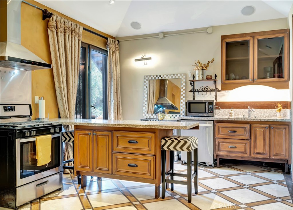 44 Hackamore Lane, Unit 46 Bell Canyon, CA 91307 - Photo 10 of 17 a kitchen with a stove a sink and chairs