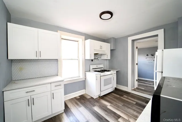 a kitchen with granite countertop white cabinets and white appliances