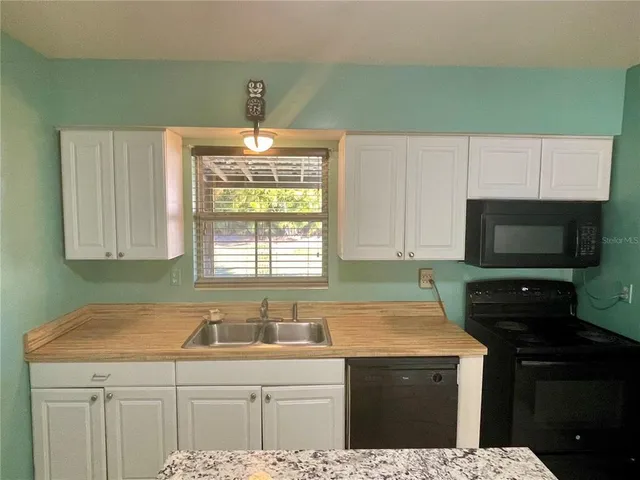 a kitchen with a sink a stove and cabinets