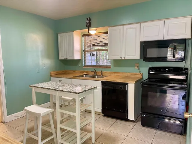 a kitchen with granite countertop a stove cabinets and microwave