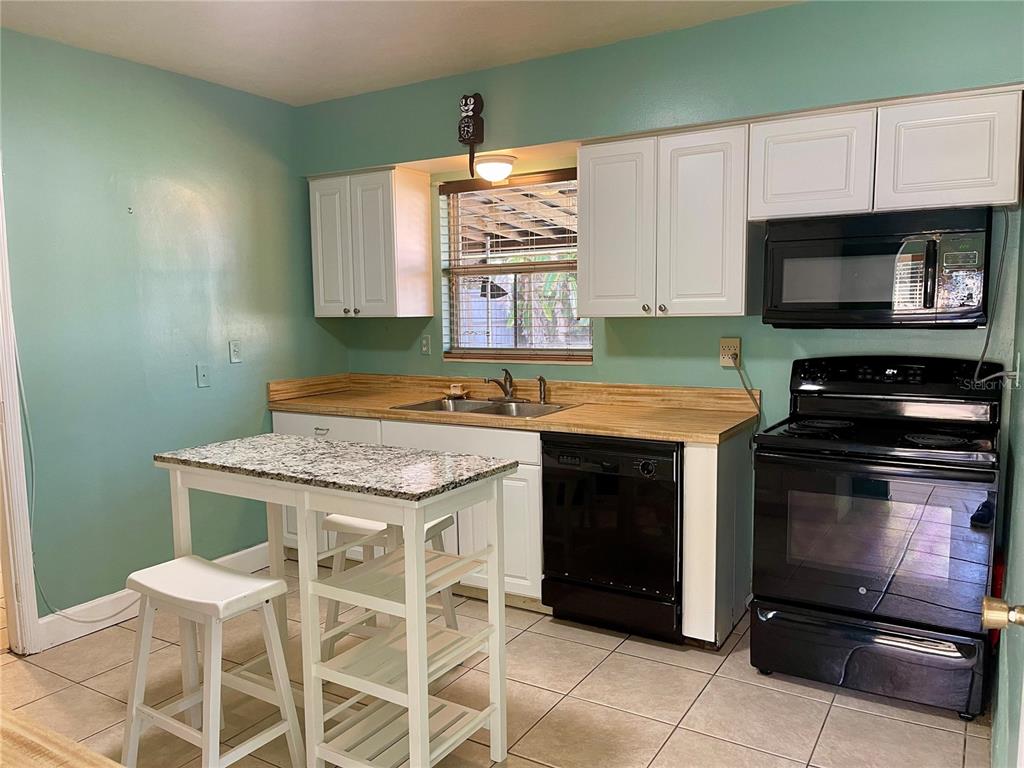2043 Cordes Street Osprey, FL 34229 - Photo 8 of 35 a kitchen with granite countertop a stove cabinets and microwave