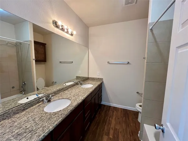 a bathroom with a granite countertop sink a large mirror and a shower