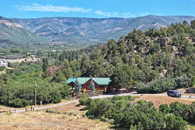 a view of a house with a yard and wooden fence