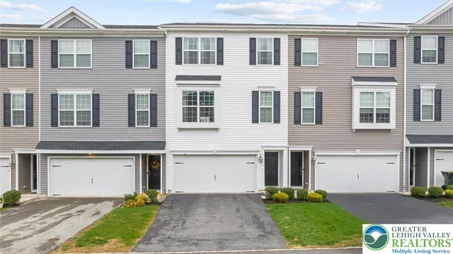 a front view of a house with a yard and trees
