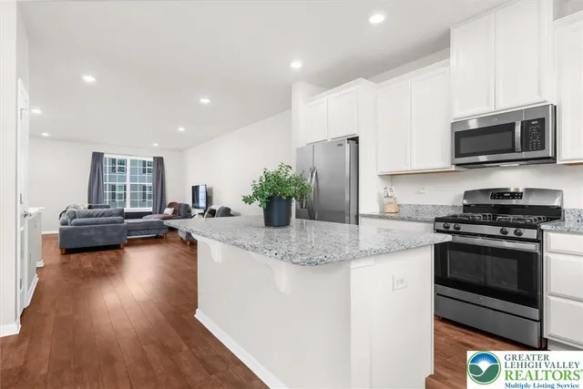 a kitchen with stainless steel appliances granite countertop a stove a sink and a microwave