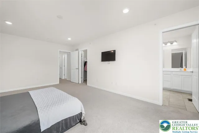 a spacious bedroom with a bed and a painting on the wall