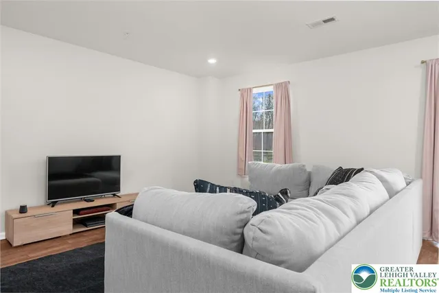 a living room with couches and a flat screen tv