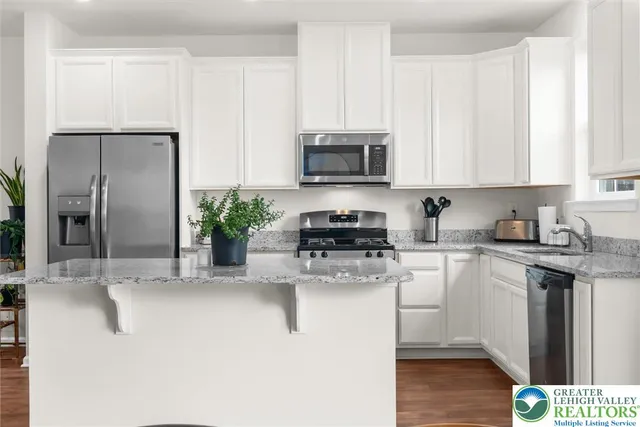 a kitchen with stainless steel appliances granite countertop a refrigerator sink and microwave
