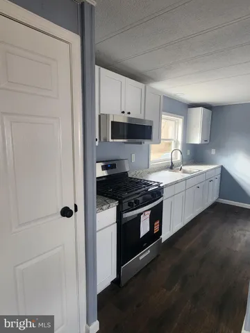 a kitchen with stainless steel appliances a sink stove and cabinets