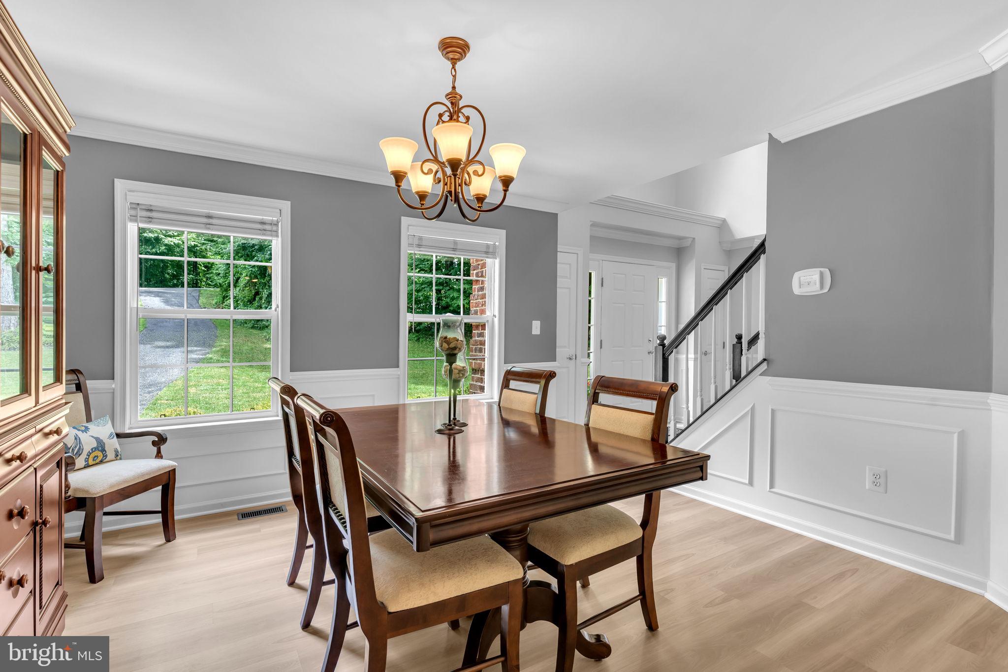 204 Walnut Creek Road Huntingtown, MD 20639 - Photo 17 of 59 a view of a dining room with furniture a chandelier and wooden floor