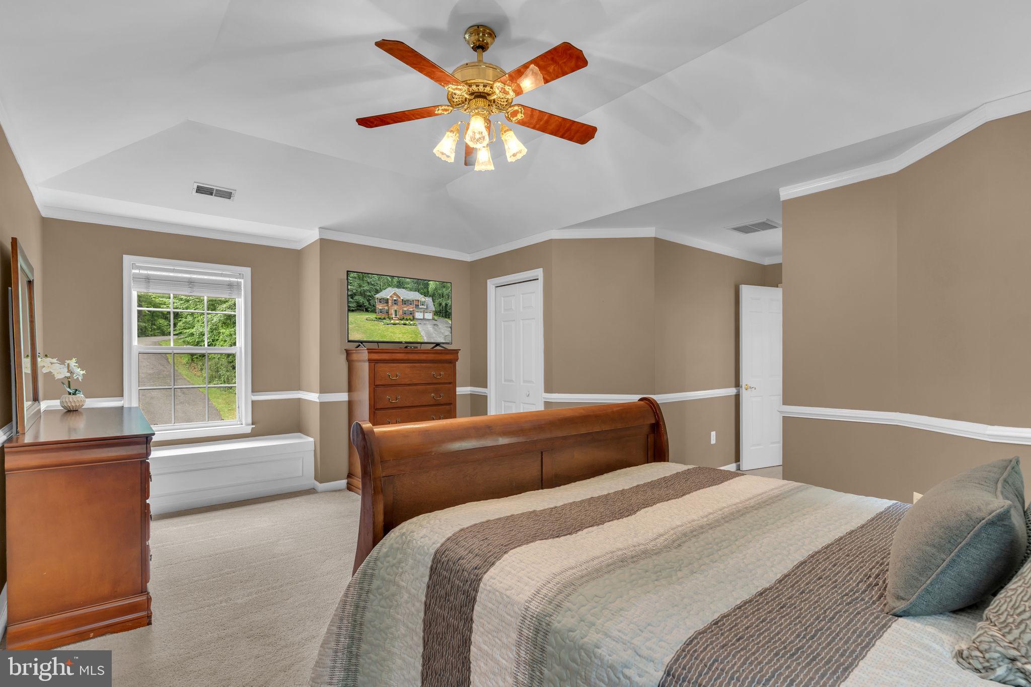 204 Walnut Creek Road Huntingtown, MD 20639 - Photo 26 of 59 a bedroom with a large bed and a chandelier