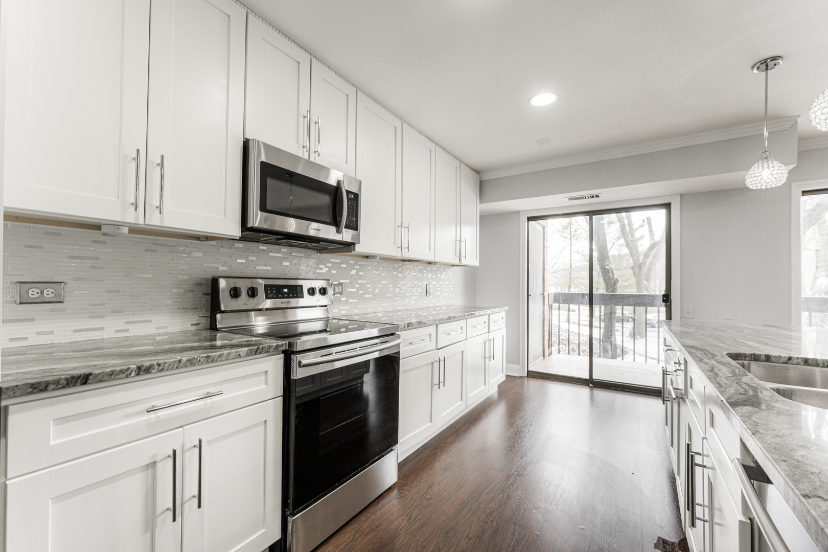 1831 Mission Hills Road, Unit 106 Northbrook, IL 60062 - Photo 8 of 37 a kitchen with stainless steel appliances granite countertop a stove sink microwave and cabinets
