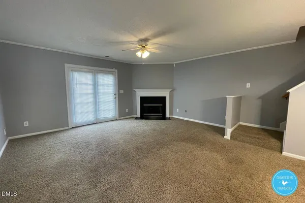 an empty room with windows and fireplace