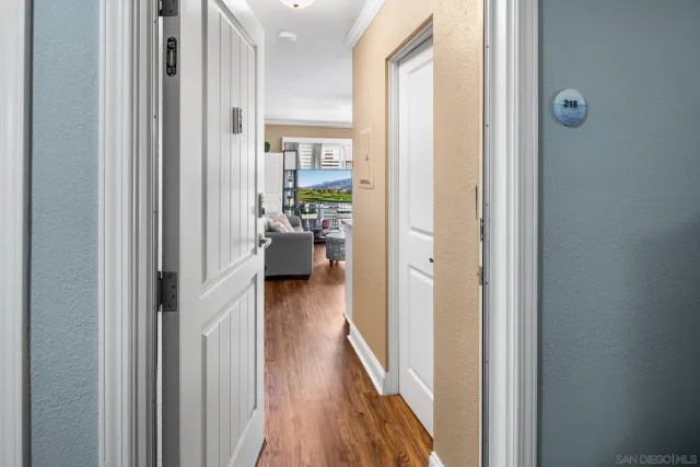 a view of a hallway with wooden floor windows and a livingroom
